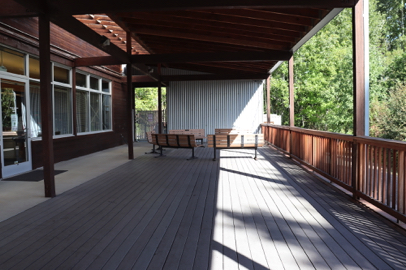 Deck at Education Center – covered area – railing – several benches with backs – view of wetlands